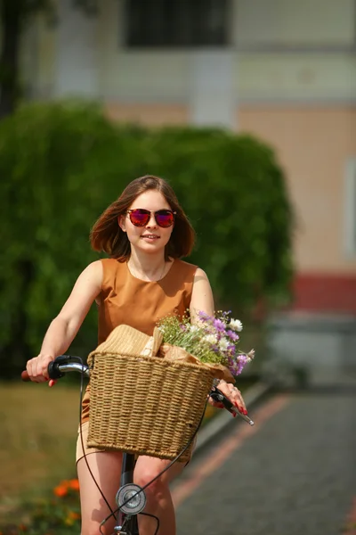 Flot ung kvinde med cykel i parken - Stock-foto