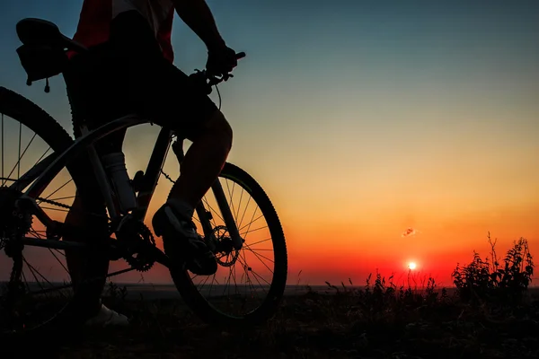 Silhouette eines Radfahrers und eines Fahrrads auf Himmelshintergrund. — Stockfoto