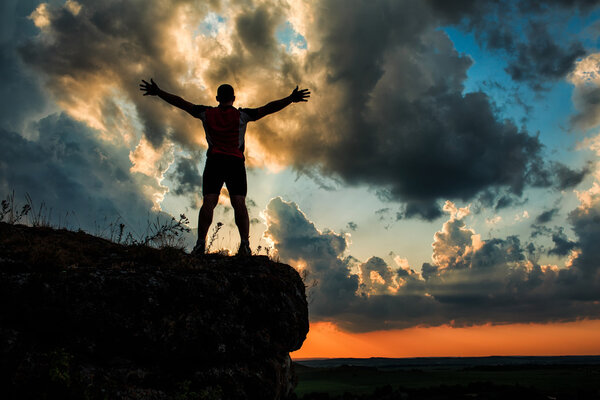 Один парень стоит на камне
