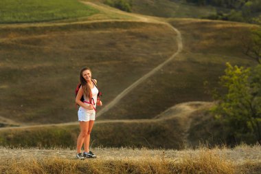 Gün batımı yaz yürüyüş kırmızı sırt çantası olan kadın.