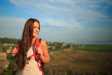 Gün batımı yaz yürüyüş kırmızı sırt çantası olan kadın.