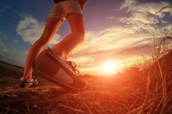 Close up of feet sportwoman in autumn grass — Stock Photo, Image