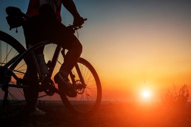 Silhouette bir motorcu ve gökyüzü arka plan üzerinde bisiklet.