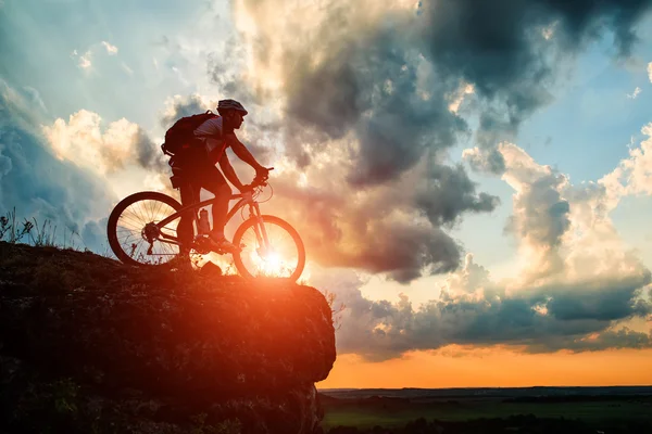 Silhueta de um motociclista e bicicleta no fundo do céu . — Fotografia de Stock