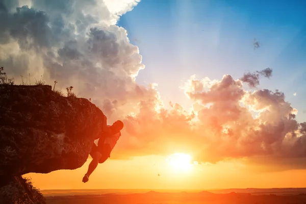 Un ragazzo si siede su una roccia a guardare il tramonto — Foto Stock