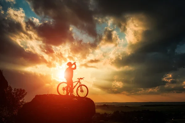 Silhouette eines Radfahrers und eines Fahrrads auf Himmelshintergrund. — Stockfoto