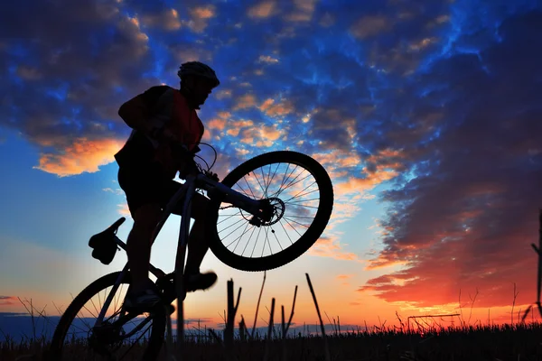 Σιλουέτα του ένα biker και το ποδήλατο σε φόντο του ουρανού. — Φωτογραφία Αρχείου