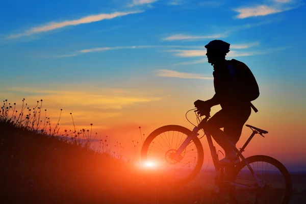 Silhouette of a biker and bicycle on sky background. — Stock Photo, Image