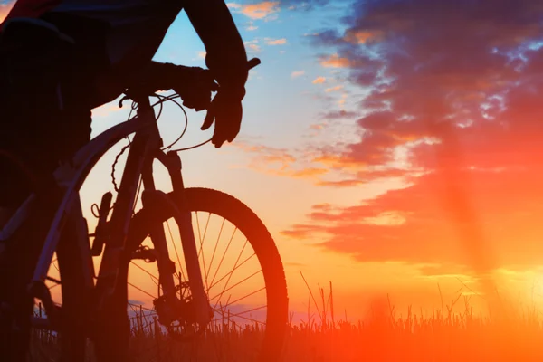 バイクに乗る人、夕日を背景に自転車のシルエット. — ストック写真