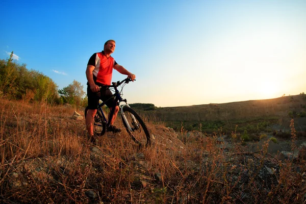 Ciclista joven adulto montando bicicleta de montaña en el campo — Foto de Stock