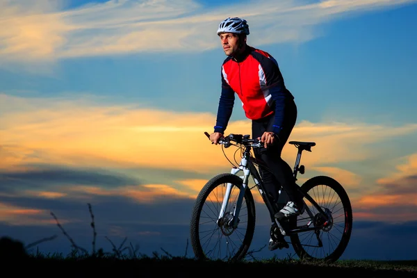 Giovane ciclista adulto in mountain bike in campagna — Foto Stock