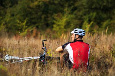 bisikletçi bisiklet ile güneşli sonbahar Park'ta rahatlayın
