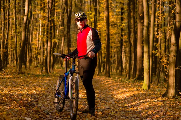 Hombre con bicicleta montando carretera país — Foto de Stock