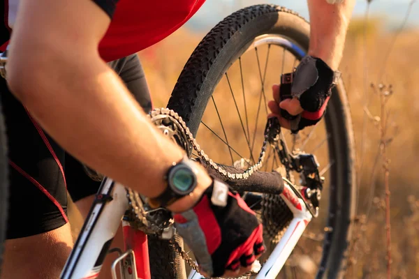 Ung man reparera mountainbike i skogen — Stockfoto