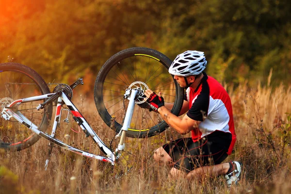 Reparación. Joven reparando bicicleta de montaña —  Fotos de Stock