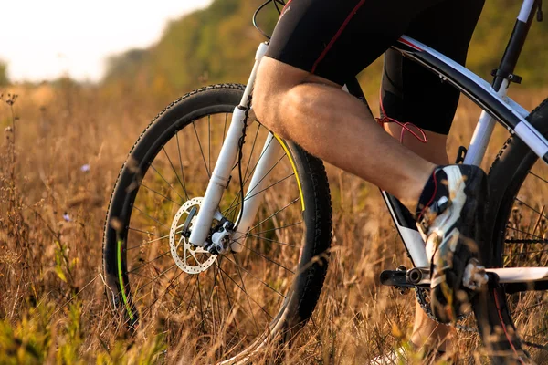 Cyclist man legs riding mountain bike on outdoor trail in autumn forest — Stock Photo, Image