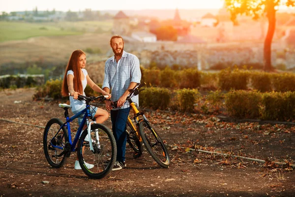 Mutlu genç çift bicyclists sokağın ortasında konuşuyor — Stok fotoğraf