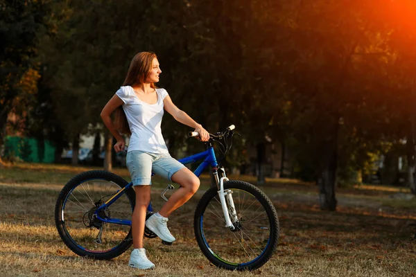 Adolescente com bicicleta no parque da cidade — Fotografia de Stock