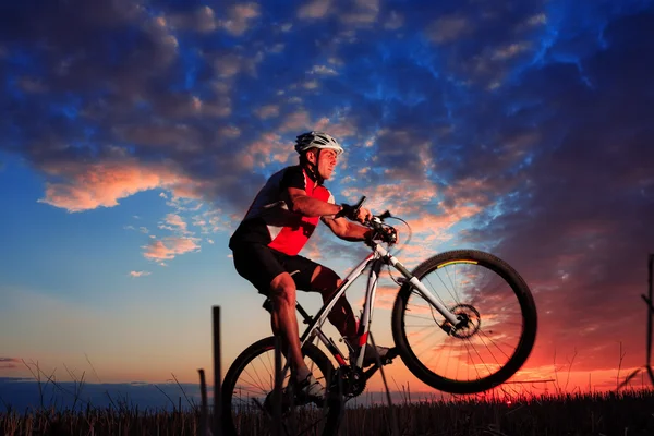 Mann mit Fahrrad bei Sonnenuntergang im Freien — Stockfoto