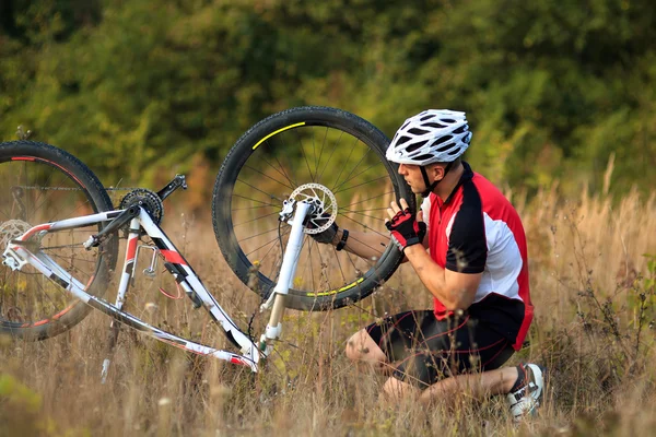 Hombre reparando su bicicleta de montaña —  Fotos de Stock