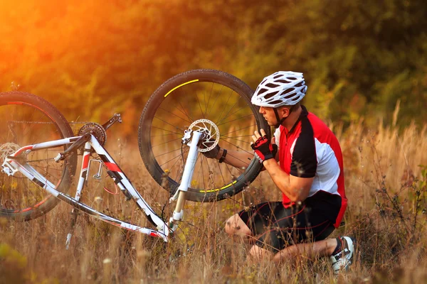 Hombre reparando su bicicleta de montaña —  Fotos de Stock