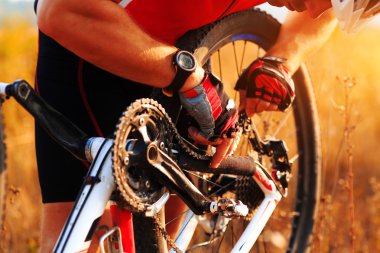 çayır üzerinde bisiklet bisikletçi onarır