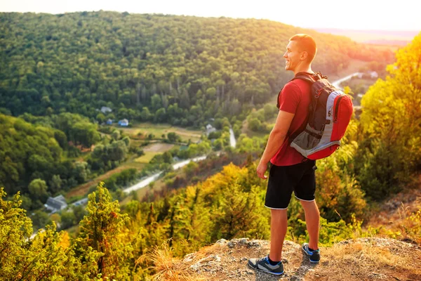 Wanderer mit Rucksack steht auf einem Berg — Stockfoto