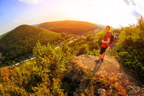 Vandrare med ryggsäck står på toppen av ett berg — Stockfoto