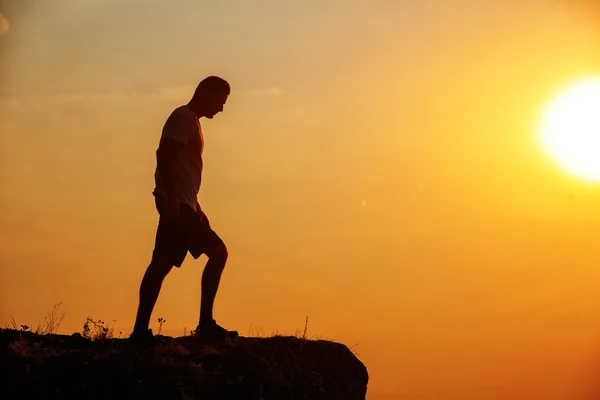 Man stands near the cross on top of mountain — Stock Photo, Image