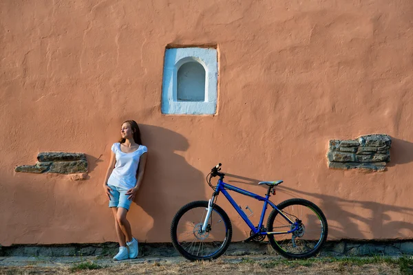 Ung kvinna sensuell poserar med cykel i city — Stockfoto