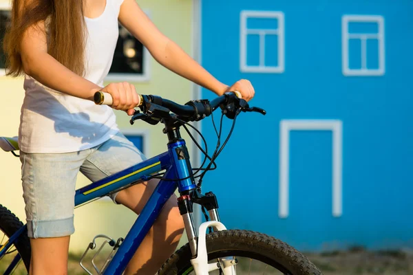 Hænderne på den unge kvinde sidder på cykel - Stock-foto