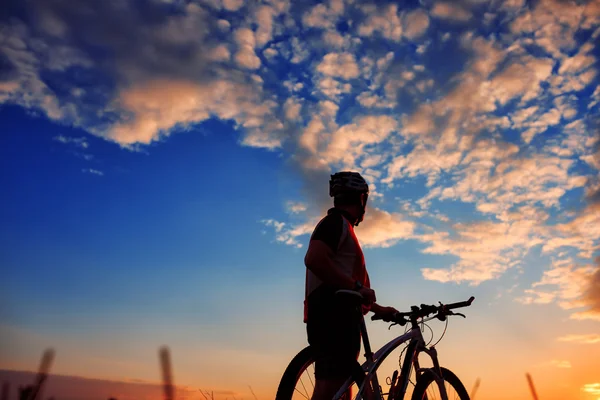 Radler mit Fahrrad bei Sonnenuntergang — Stockfoto