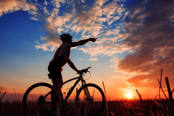 Man cyklist med cykel på sunset — Stockfoto