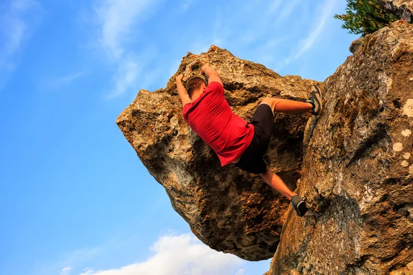 Jovem escalando em uma parede — Fotografia de Stock