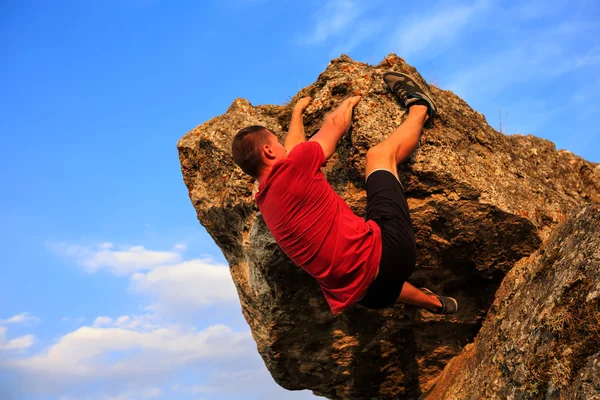 Junger Mann klettert auf Mauer — Stockfoto