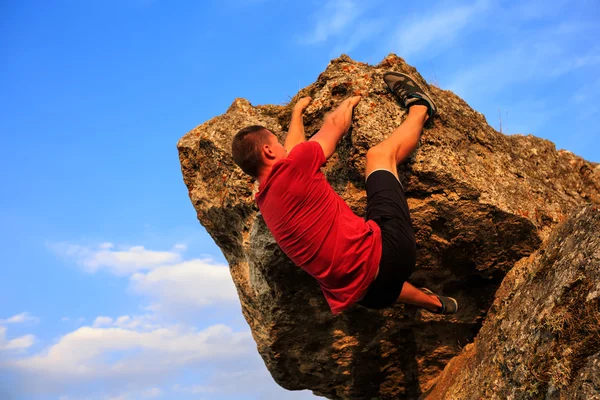 Jeune homme grimpant sur un mur — Photo