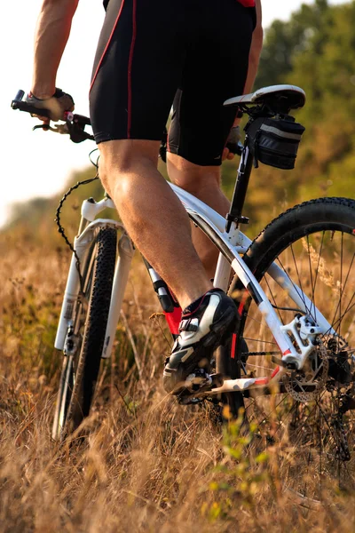 Ciclista montar en bicicleta de montaña en el camino rocoso — Foto de Stock