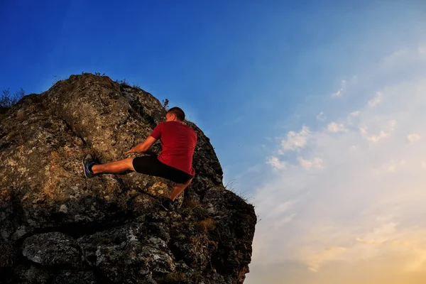 Jonge man klimmen op een muur — Stockfoto