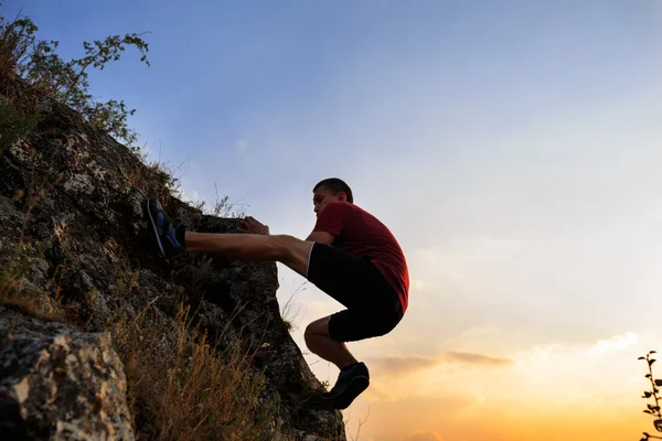 Junger Mann klettert auf Mauer — Stockfoto