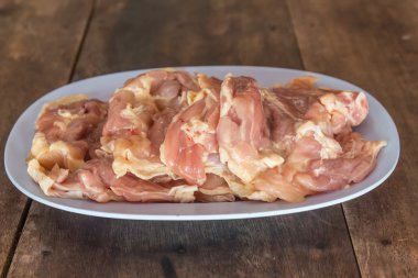 Ahşap masa üzerinde çiğ tavuk et parçası.