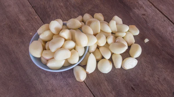 Knoblauch in Schale auf Holztisch. — Stockfoto