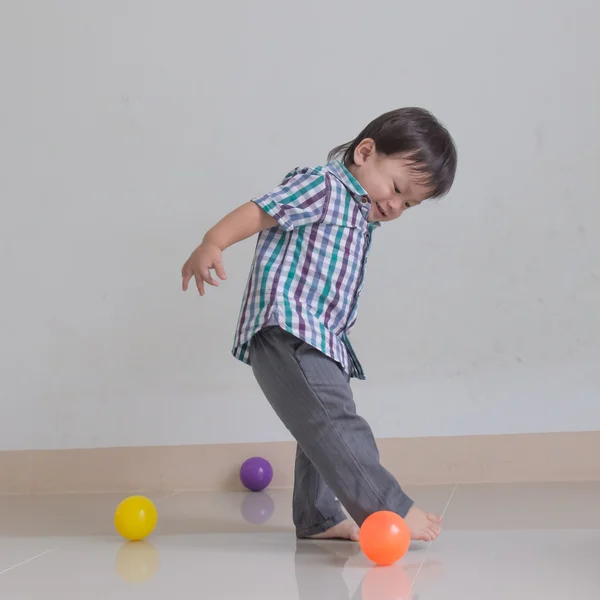 Uma criança brincando com uma bola — Fotografia de Stock