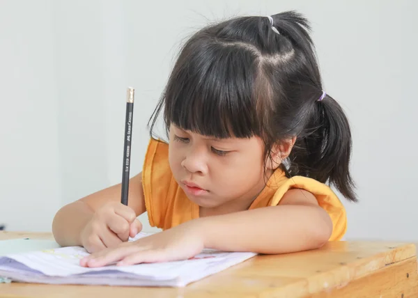 Linda niña feliz escribiendo algo en su cuaderno —  Fotos de Stock