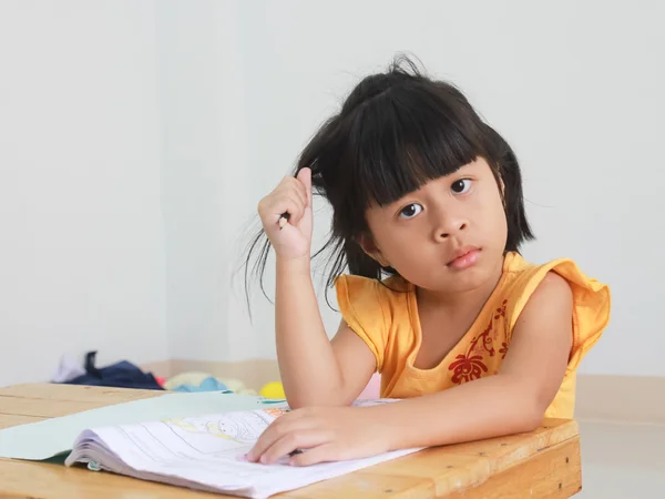 Linda niña feliz escribiendo algo en su cuaderno —  Fotos de Stock