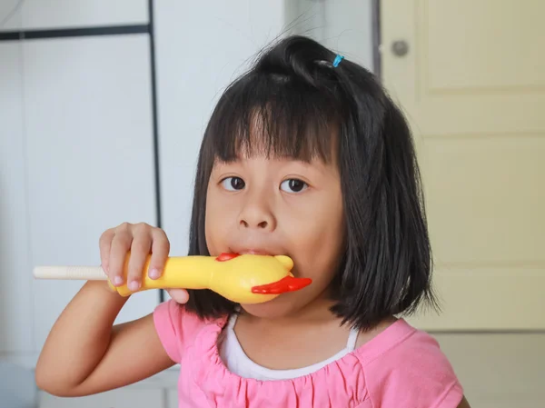 Flicka blåses kyckling leksak med ljud. — Stockfoto