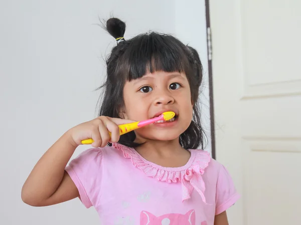 Niño sonriendo mientras se cepilla los dientes — Foto de Stock