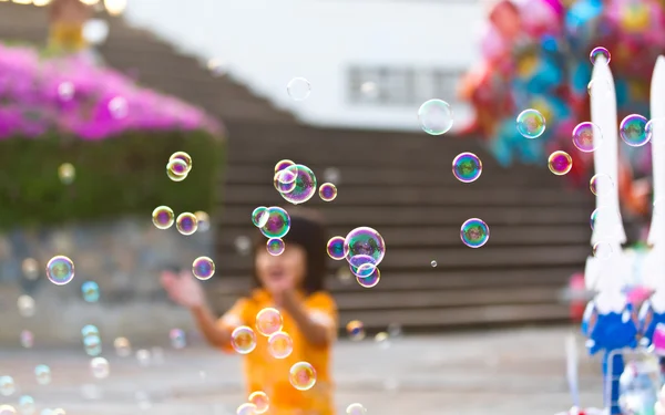 小さな女の子の背景に泡を吹いてください。 — ストック写真