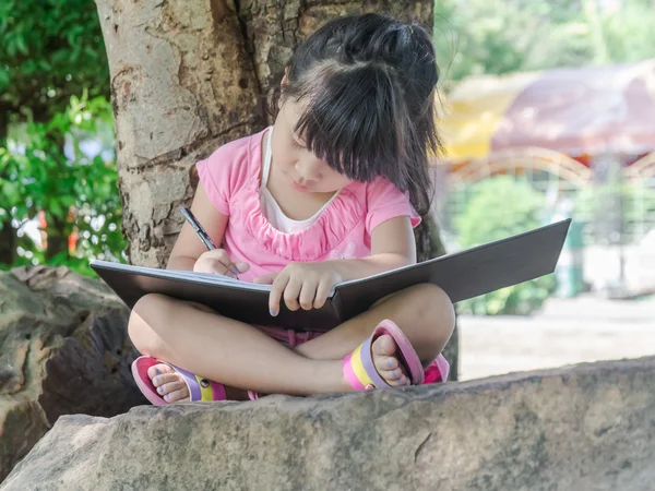 Retrato al aire libre de una linda niña escribiendo un libro —  Fotos de Stock