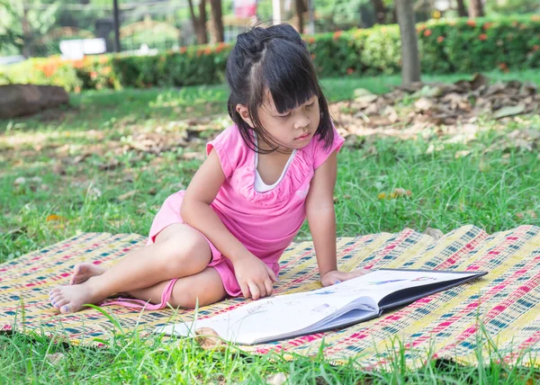 Venkovní portrét roztomilá holčička, čtení knihy — Stock fotografie