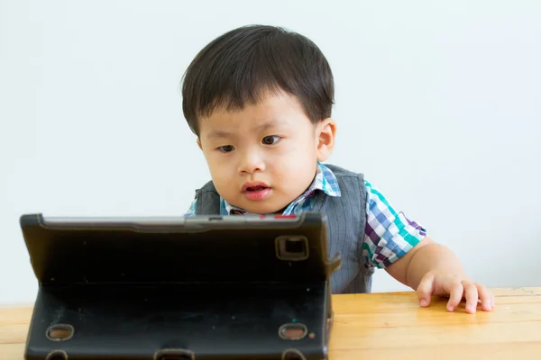 Portrait of child on table in a digital tablet — Stock Photo, Image